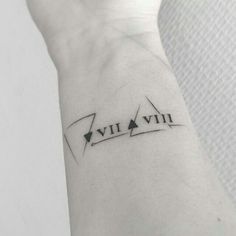 a wrist tattoo with an arrow and the word vivi on it's left arm