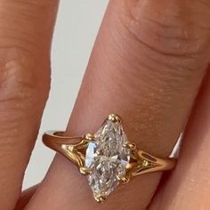 a close up of a person's hand with a diamond ring on their finger