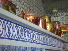 blue and white tiles with gold pots on the shelf