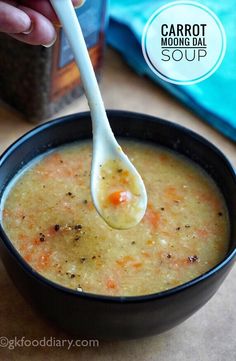 a person holding a spoon full of soup