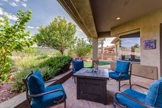 a patio with blue chairs and a table