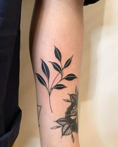 a woman's leg with a black and white flower tattoo on her left arm