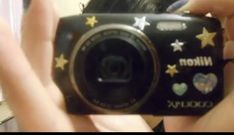 a person taking a photo with a camera in front of a mirror that has stars and hearts on it