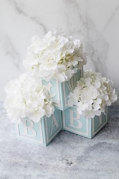 two blue boxes with white flowers in them