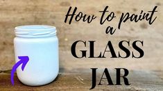 a glass jar sitting on top of a wooden table with the words how to paint a glass jar