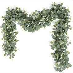 an arrangement of green leaves and flowers on a white background