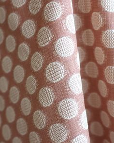 the curtain is made up with polka dots on pink and white fabric, as well as an orange background