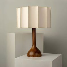 a wooden table lamp sitting on top of a white block