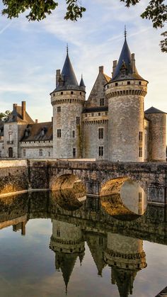 an old castle is reflected in the water