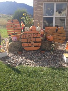 a sign that says happy fall and pumpkins are on the rocks in front of a house