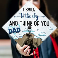 a woman holding up a graduation cap that says, i smile to the sky and think of you dad