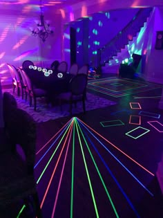 a room filled with tables and chairs covered in neon colored light strips on the floor