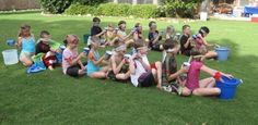 a group of children sitting on the grass