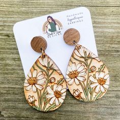 the wooden earrings are decorated with daisies