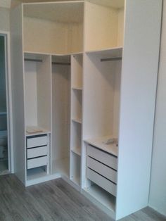 an empty white closet with drawers and shelves