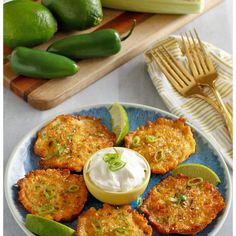 some food that is on a plate with sour cream and limes next to it