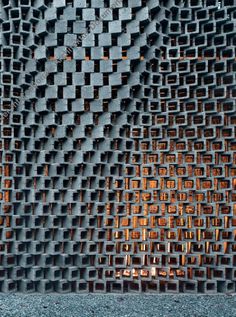 a close up view of a metal grate with orange light reflecting on it's surface