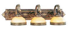 three lights are on the wall with an ornate design and gold trimmings in this bathroom fixture