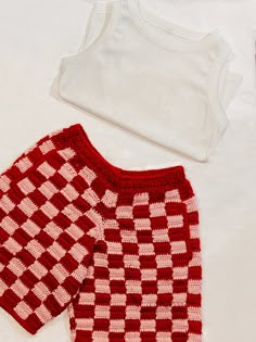 two red and white knitted clothing laying next to each other