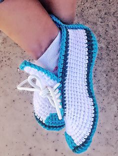 a pair of white and blue crocheted shoes