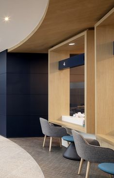 an empty room with several chairs and tables in the center, along with blue accented walls