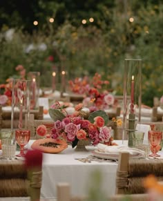 the table is set with flowers, candles and watermelon slices for an elegant dinner