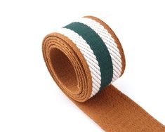 a brown and white ribbon with green stripes on it's end, against a white background