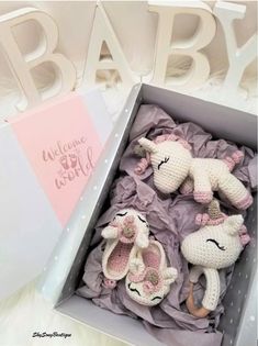 a box filled with stuffed animals next to a baby's name sign on the wall