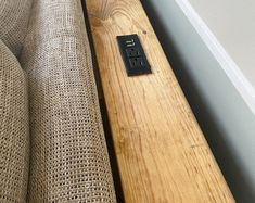 a remote control sitting on top of a wooden table next to a window sill