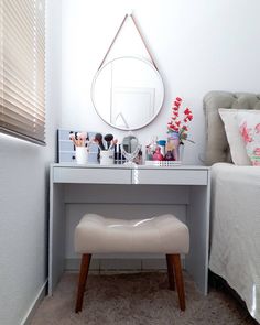 a white desk with a mirror, stool and other items sitting on top of it