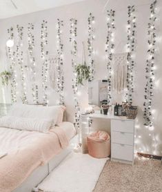 a bedroom decorated with white lights and greenery on the wall, along with a bed