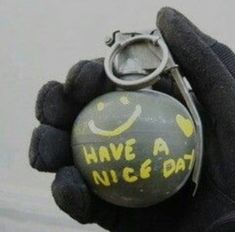 a hand holding a ball with smiley face drawn on it and a pair of scissors