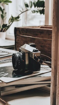 a camera sitting on top of a book next to a window