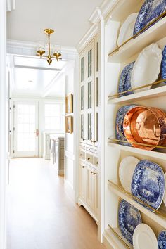 a kitchen with blue and white dishes on shelves