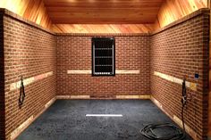 an empty room with brick walls and black hoses on the floor next to it