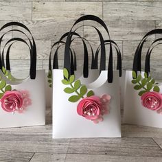 four small bags with flowers on them sitting on a wooden floor next to each other