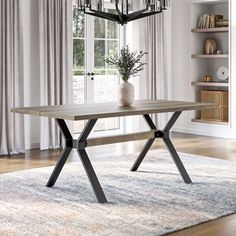 a dining room table with a chandelier hanging from it's centerpiece