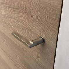 a close up of a door handle on a wooden cabinet