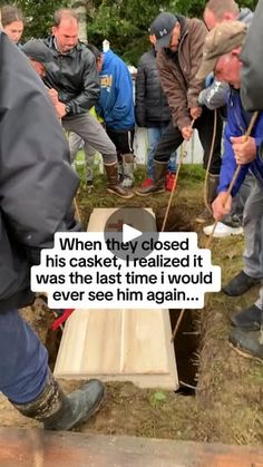 a group of men standing around a hole in the ground with one man holding a shovel