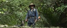 a man with two dogs walking through the woods