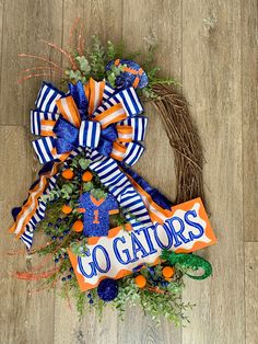 an orange, white and blue wreath with the word go gators tied to it