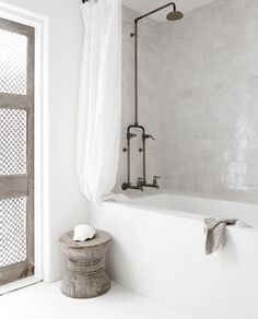 a white bathroom with a tub and shower