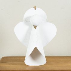 a toilet paper sculpture sitting on top of a wooden table