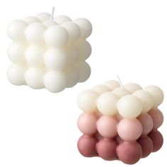 two candles with white and pink balls on them, one is shaped like a cloud