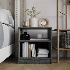 a book shelf with books, vases and other items on it next to a bed