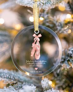 a glass ornament with a ballerina's shoe on it hanging from a christmas tree