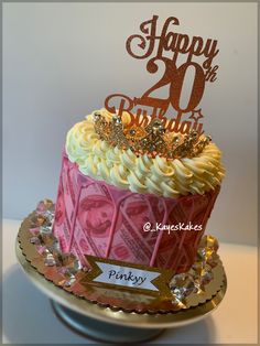 a pink and gold birthday cake sitting on top of a plate with a happy 20th birthday sign