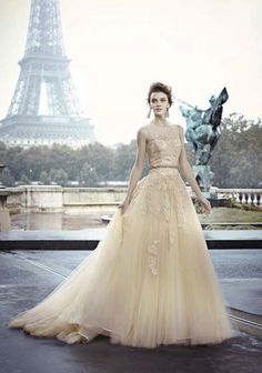 a woman is standing in front of the eiffel tower wearing a dress with flowers on it