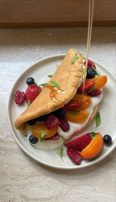 a white plate topped with pancakes covered in fruit