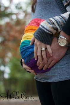 a woman holding her hands on top of a ball of yarn